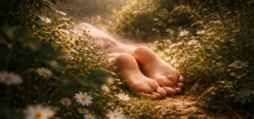 Bose stopy leżące na leśnej ścieżce wśród kwiatów i ciepłego światła zachodu słońca – symboliczna ilustracja snu o nagości i poczucia naturalności.